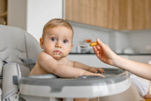 A baby turning away from food on a spoon